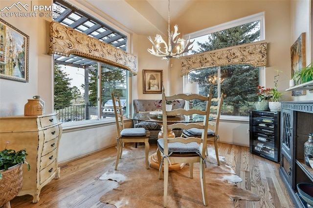 8005 Hedgewood Way, Colorado Springs, CO 80919 - dining room featuring a chandelier, wood finished floors, a towering ceiling, and beverage cooler