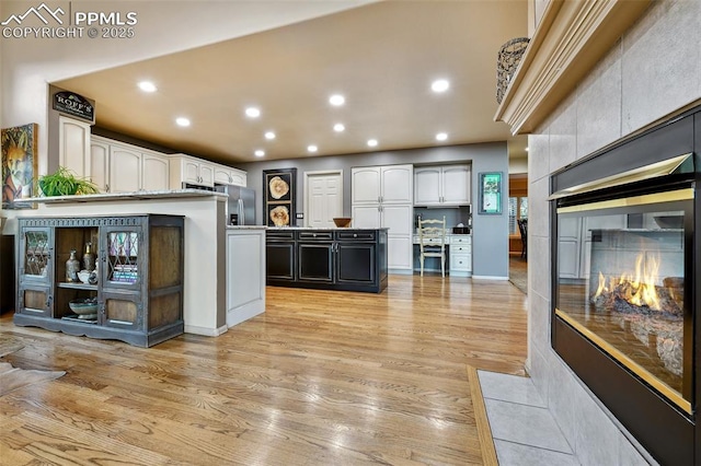 8005 Hedgewood Way, Colorado Springs, CO 80919 - kitchen featuring light wood-type flooring, recessed lighting, white cabinetry, stainless steel fridge with ice dispenser, and a center island