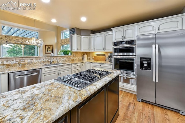 8005 Hedgewood Way, Colorado Springs, CO 80919 - kitchen featuring stainless steel appliances, a sink, a warming drawer, light wood finished floors, and white cabinets