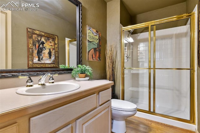 8005 Hedgewood Way, Colorado Springs, CO 80919 - full bathroom featuring a stall shower, toilet, wood finished floors, and vanity