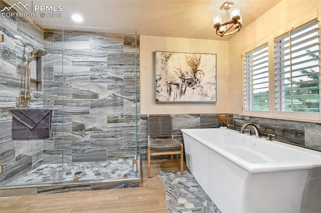 8005 Hedgewood Way, Colorado Springs, CO 80919 - full bathroom featuring a stall shower, a soaking tub, wood finished floors, and tile walls
