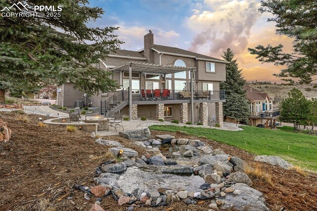 8005 Hedgewood Way, Colorado Springs, CO 80919 - rear view of house featuring a pergola, a chimney, a patio area, stucco siding, and a deck