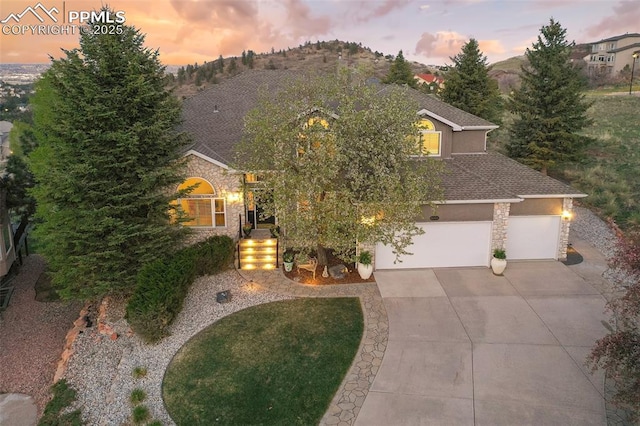 8005 Hedgewood Way, Colorado Springs, CO 80919 - view of front facade with driveway, stone siding, stucco siding, and a shingled roof