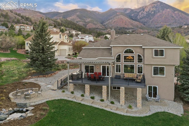 8005 Hedgewood Way, Colorado Springs, CO 80919 - rear view of house featuring an outdoor fire pit, a pergola, a deck with mountain view, and a lawn