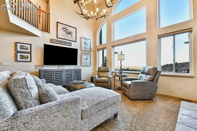 8005 Hedgewood Way, Colorado Springs, CO 80919 - living area featuring a chandelier, a towering ceiling, carpet floors, and baseboards