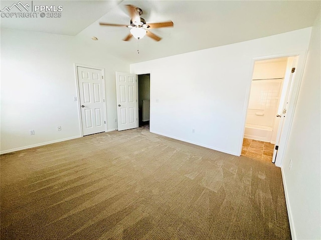 10525 Wells Pt, Fountain, CO 80817 - unfurnished bedroom featuring carpet floors, baseboards, vaulted ceiling, ensuite bathroom, and a ceiling fan