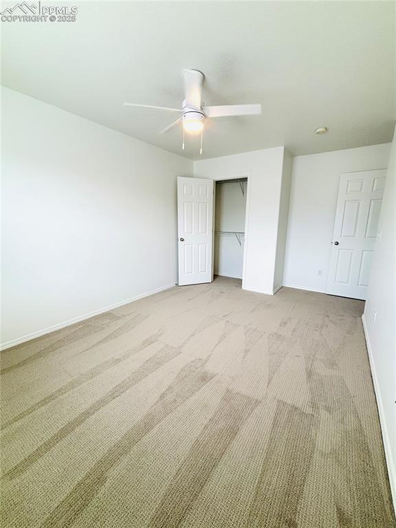 10525 Wells Pt, Fountain, CO 80817 - unfurnished bedroom with light colored carpet, baseboards, a closet, and ceiling fan