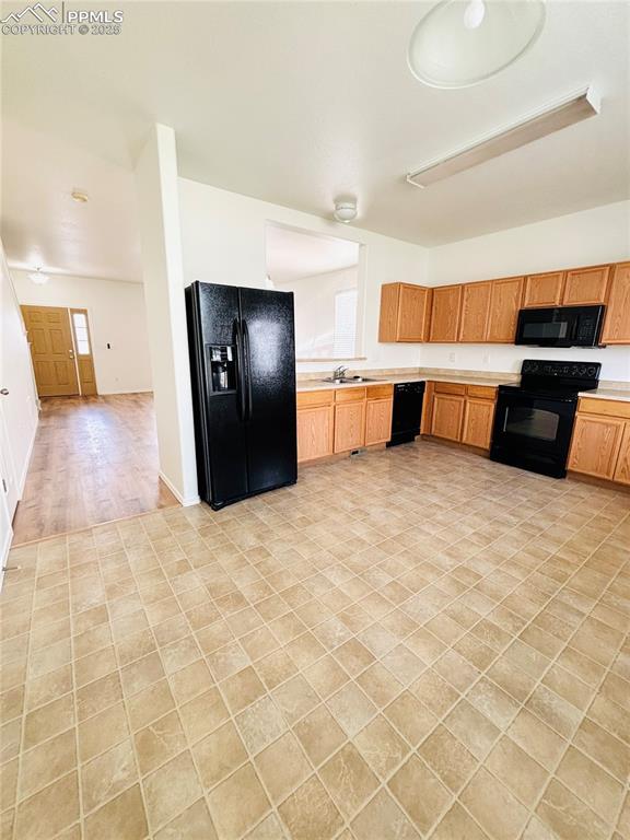10525 Wells Pt, Fountain, CO 80817 - kitchen with black appliances, light countertops, and a sink
