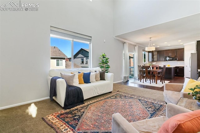 living room featuring plenty of natural light, baseboards, recessed lighting, carpet flooring, and a towering ceiling