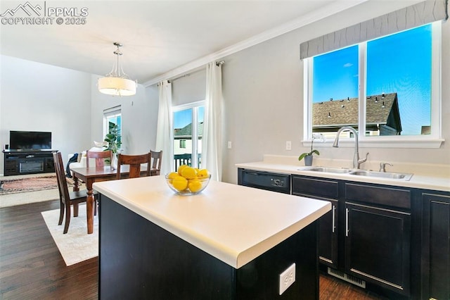 kitchen with dishwasher, a sink, dark cabinets, dark wood-type flooring, and crown molding