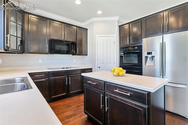 kitchen with black appliances, a sink, light countertops, dark wood-style flooring, and dark brown cabinets