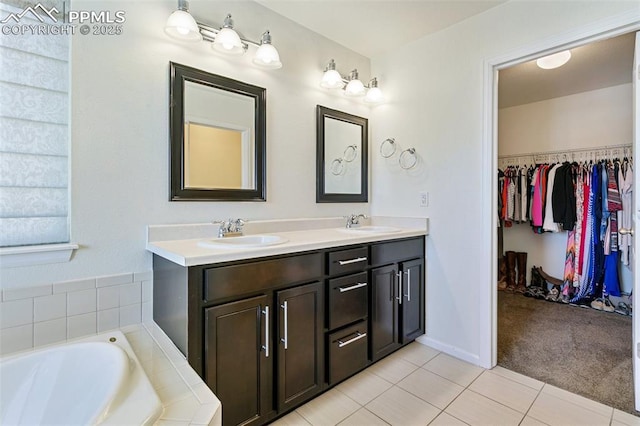 full bathroom featuring tile patterned floors, double vanity, a spacious closet, and a bath