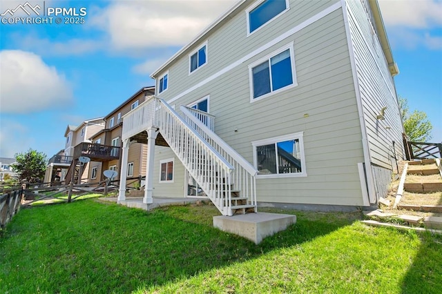 rear view of property with stairs, a wooden deck, and a patio area