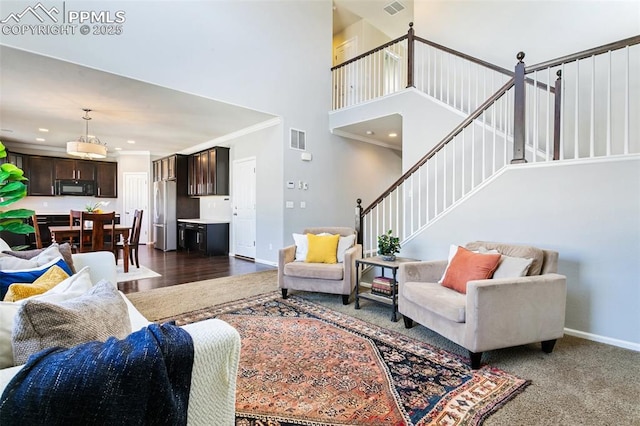 living area featuring stairway, baseboards, a high ceiling, ornamental molding, and recessed lighting