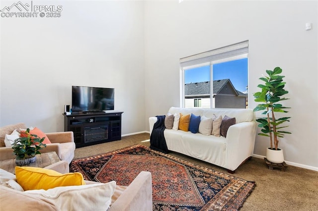living room with carpet, baseboards, and a high ceiling