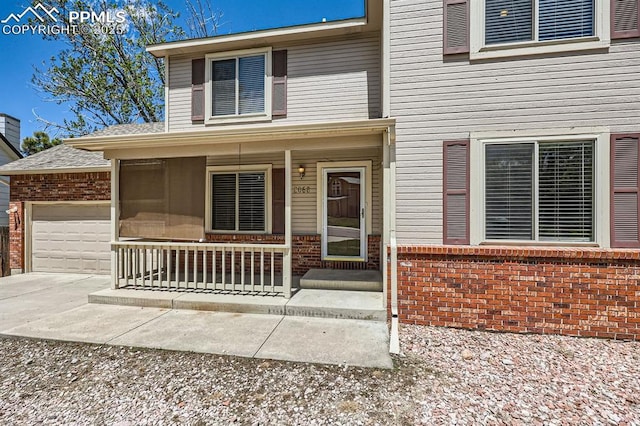 2068 Silkwood Dr, Colorado Springs, CO 80920 - view of front of home featuring a porch, brick siding, a garage, and driveway