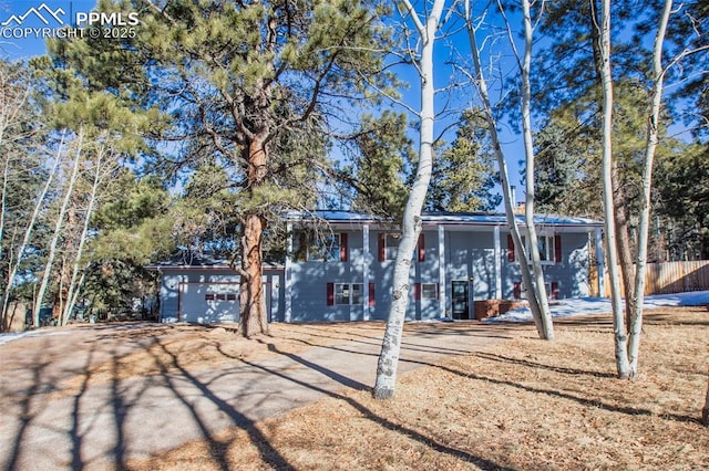 view of front of property featuring fence and a garage