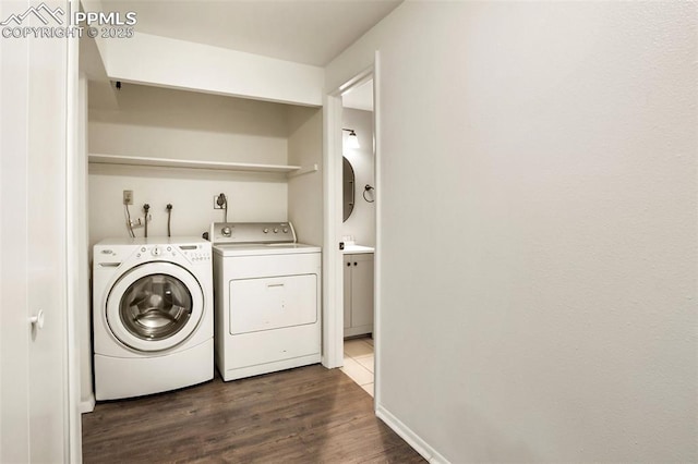 washroom with washer and dryer and dark wood-type flooring