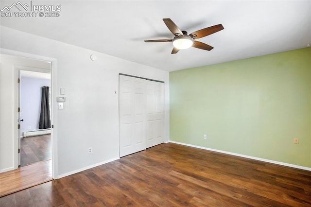 unfurnished bedroom with baseboard heating, wood finished floors, and baseboards
