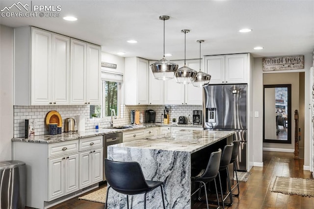 6940 Franciville Rd, Colorado Springs, CO 80908 - kitchen with stainless steel appliances, a sink, dark wood-style floors, baseboards, and white cabinetry