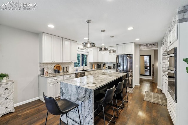 6940 Franciville Rd, Colorado Springs, CO 80908 - kitchen with stainless steel appliances, a sink, baseboards, light stone countertops, and dark wood-style flooring