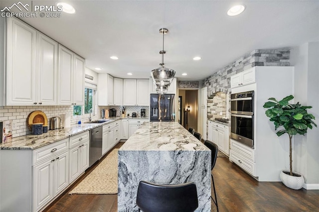 6940 Franciville Rd, Colorado Springs, CO 80908 - kitchen featuring appliances with stainless steel finishes, a sink, backsplash, light stone countertops, and white cabinetry
