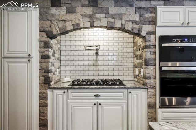 6940 Franciville Rd, Colorado Springs, CO 80908 - kitchen featuring multiple ovens, black gas stovetop, white cabinetry, and dark stone countertops