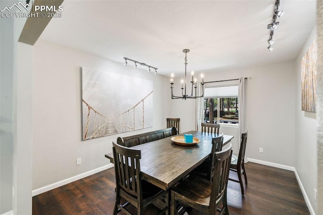 6940 Franciville Rd, Colorado Springs, CO 80908 - dining space with rail lighting, wood finished floors, a chandelier, and baseboards