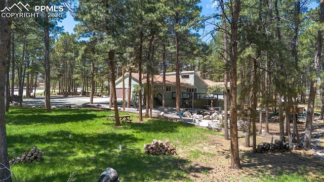 6940 Franciville Rd, Colorado Springs, CO 80908 - view of grassy yard with stairs and a wooden deck