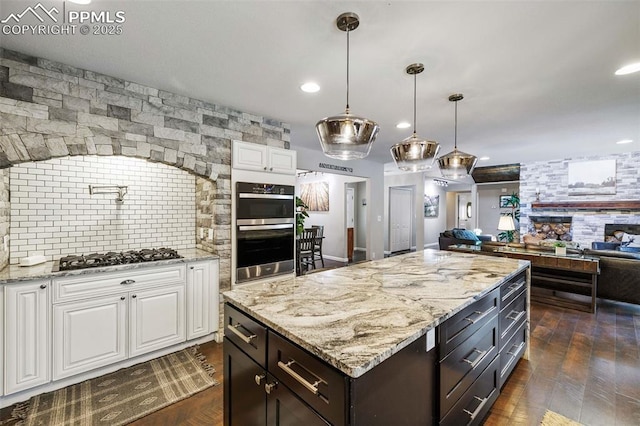6940 Franciville Rd, Colorado Springs, CO 80908 - kitchen with black gas stovetop, white cabinets, stainless steel double oven, open floor plan, and recessed lighting