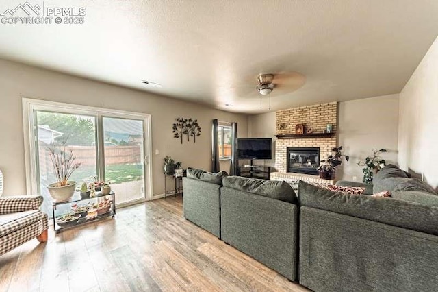 780 Foxwood Dr, Colorado Springs, CO 80911 - living area featuring wood finished floors, ceiling fan, and a fireplace