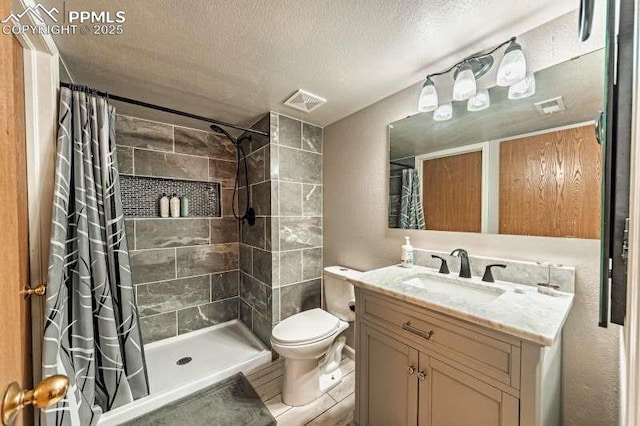 780 Foxwood Dr, Colorado Springs, CO 80911 - bathroom featuring tiled shower, a textured ceiling, vanity, and toilet