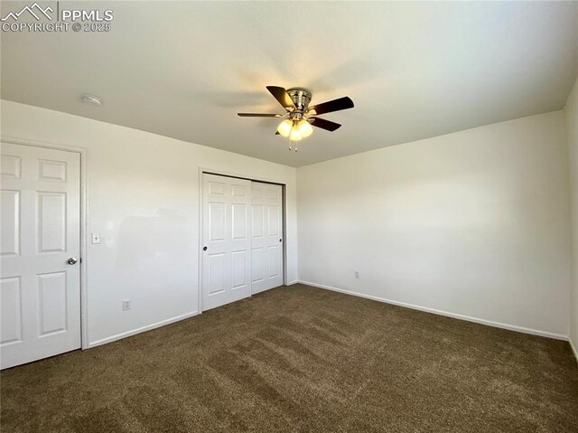 7513 Sandy Springs Pt, Fountain, CO 80817 - unfurnished bedroom with dark carpet, baseboards, and a closet