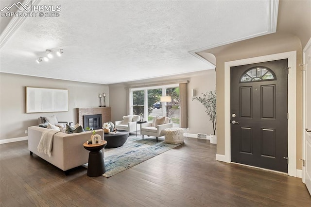 603 Three Eagles St, Colorado Springs, CO 80905 - living area with dark wood finished floors, baseboards, a textured ceiling, and a brick fireplace