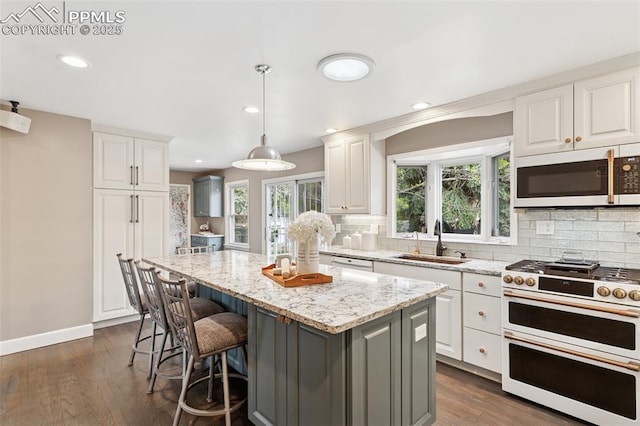 603 Three Eagles St, Colorado Springs, CO 80905 - kitchen featuring range with two ovens, a sink, white microwave, backsplash, and recessed lighting