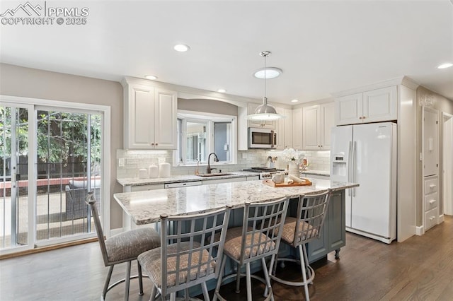 603 Three Eagles St, Colorado Springs, CO 80905 - kitchen with white fridge with ice dispenser, stainless steel microwave, dark wood-type flooring, backsplash, and recessed lighting
