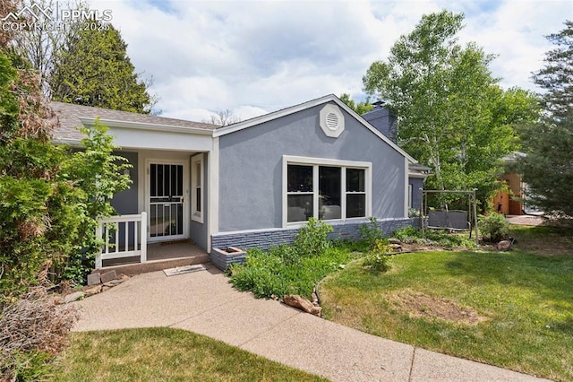 603 Three Eagles St, Colorado Springs, CO 80905 - view of front facade with a front lawn, stucco siding, and a chimney