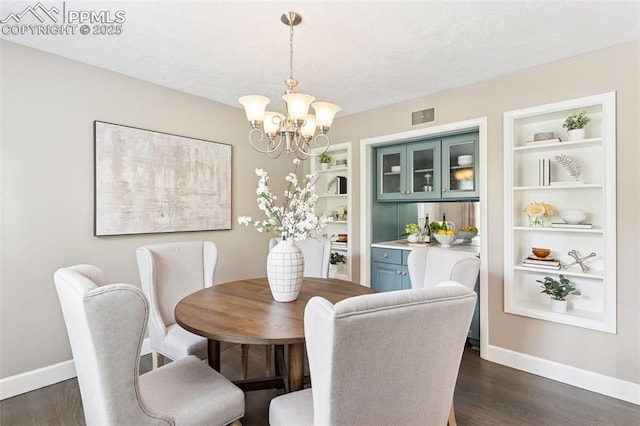 603 Three Eagles St, Colorado Springs, CO 80905 - dining room featuring baseboards, a chandelier, dark wood finished floors, built in features, and a textured ceiling