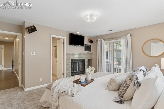 603 Three Eagles St, Colorado Springs, CO 80905 - bedroom featuring a tiled fireplace, baseboards, access to exterior, carpet floors, and connected bathroom