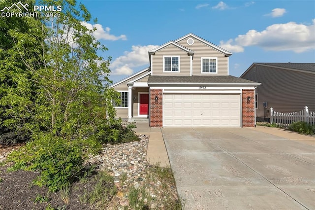8463 Shadow Run Ln, Fountain, CO 80817 - traditional-style house with brick siding, driveway, an attached garage, and fence