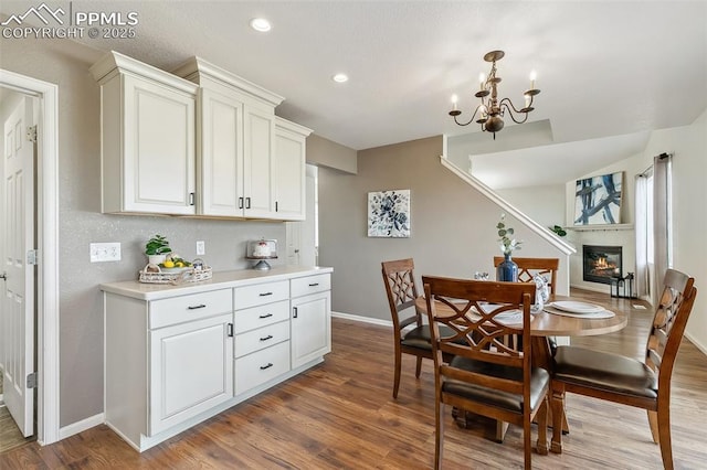 8463 Shadow Run Ln, Fountain, CO 80817 - dining room featuring baseboards, wood finished floors, a chandelier, recessed lighting, and a glass covered fireplace