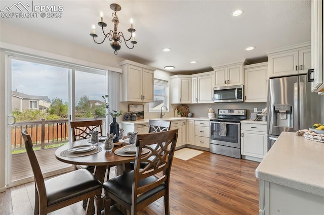 8463 Shadow Run Ln, Fountain, CO 80817 - kitchen featuring stainless steel appliances, light countertops, wood finished floors, a chandelier, and recessed lighting