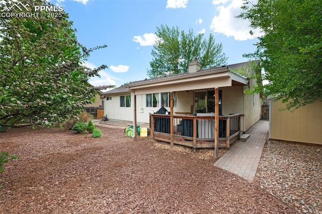 629 Golden Eagle Dr, Colorado Springs, CO 80916 - back of property featuring a wooden deck, a chimney, stucco siding, fence, and an outdoor structure