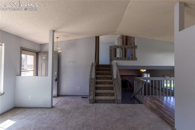 7630 Pebble Path Pl, Colorado Springs, CO 80920 - unfurnished living room with carpet flooring, baseboards, a textured ceiling, and lofted ceiling