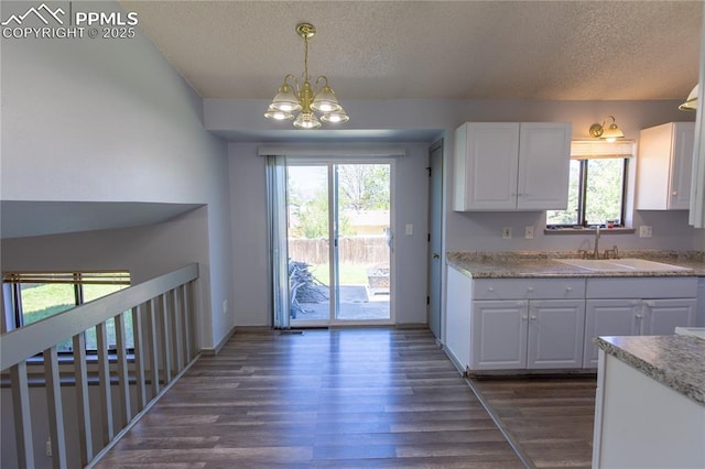 7630 Pebble Path Pl, Colorado Springs, CO 80920 - kitchen with a textured ceiling, a sink, white cabinets, dark wood finished floors, and a chandelier
