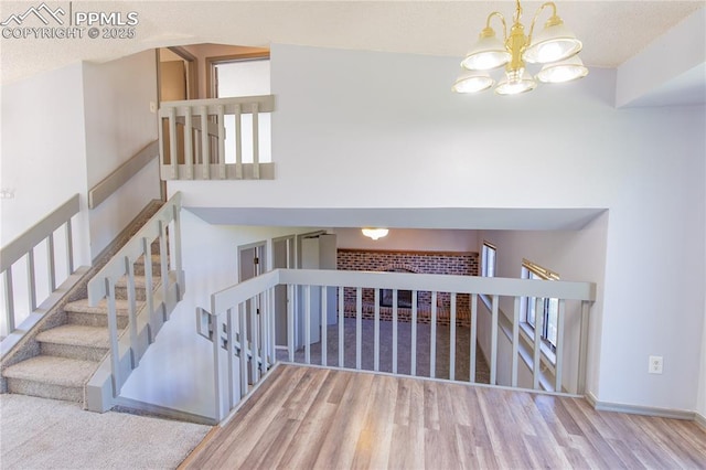 7630 Pebble Path Pl, Colorado Springs, CO 80920 - stairs with wood finished floors, a chandelier, and baseboards