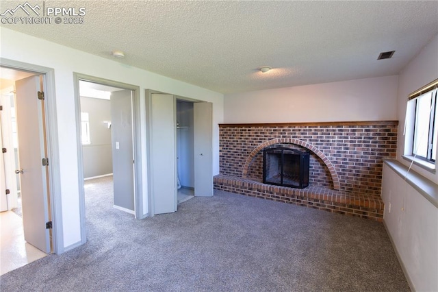 7630 Pebble Path Pl, Colorado Springs, CO 80920 - unfurnished living room with carpet floors, a textured ceiling, and a fireplace