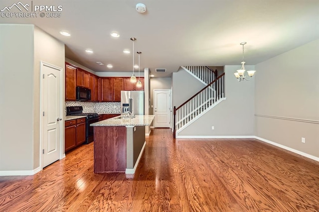 8883 White Prairie Vw, Colorado Springs, CO 80924 - kitchen featuring black appliances, wood finished floors, backsplash, pendant lighting, and recessed lighting
