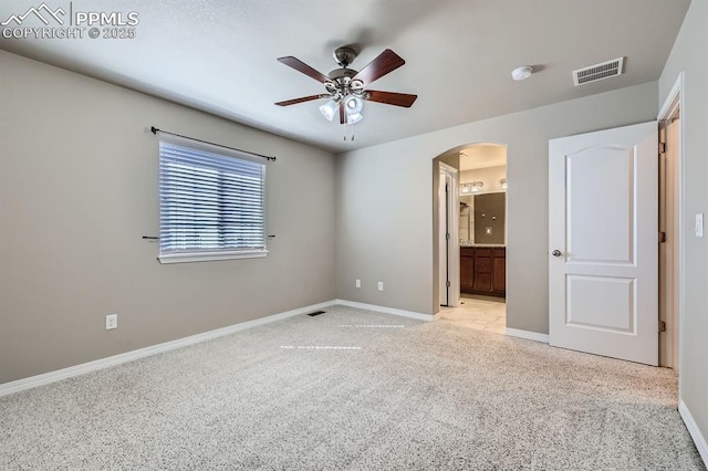 8883 White Prairie Vw, Colorado Springs, CO 80924 - unfurnished bedroom featuring arched walkways, baseboards, carpet floors, ensuite bathroom, and ceiling fan