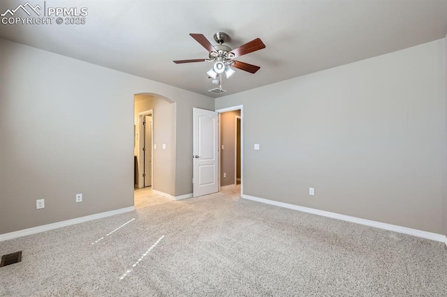 8883 White Prairie Vw, Colorado Springs, CO 80924 - empty room with arched walkways, ceiling fan, baseboards, and light colored carpet